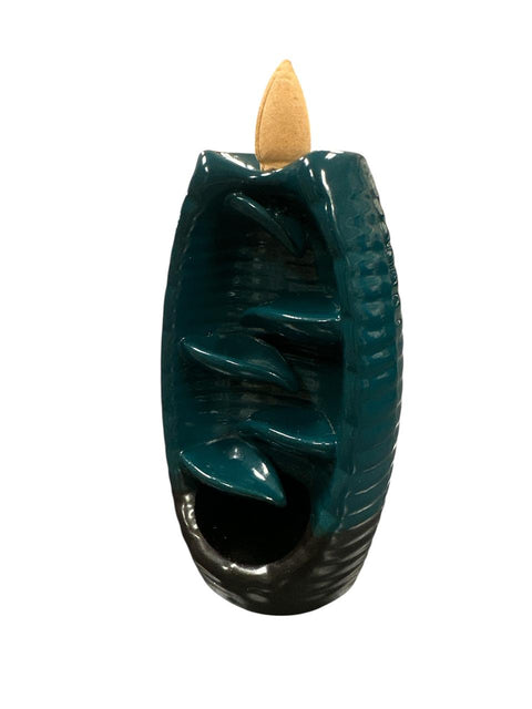 Teal backflow incense burner with a wooden cone on a white background