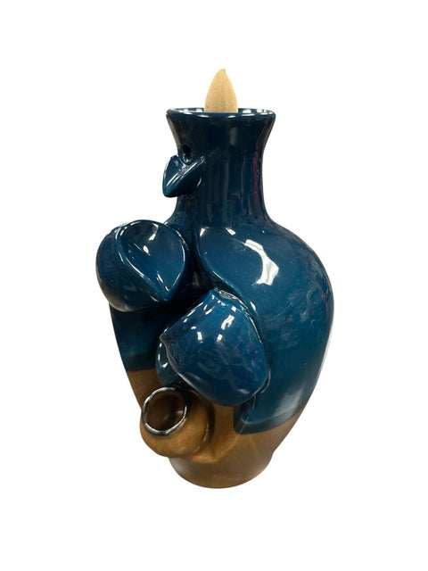 Blue ceramic incense burner with wooden base on a white background