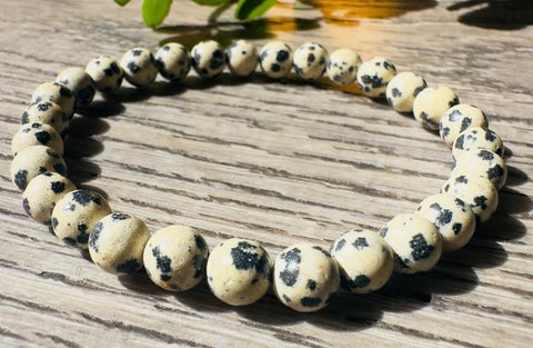 Beaded bracelet with black spots on a wooden surface