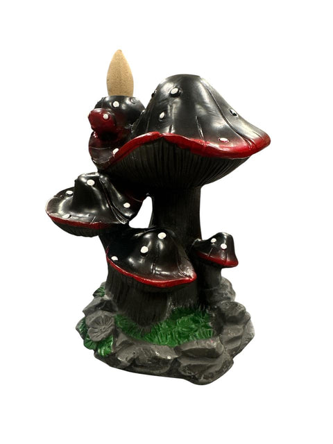 Mushroom-shaped incense burner with red caps and black bodies on a white background