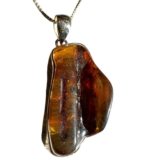 Amber pendant with silver setting on a white background