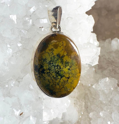 Pendant with a yellow and black marbled stone on a white crystal background