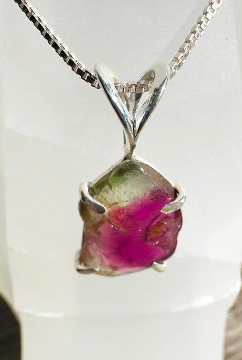 Silver pendant with a colorful gemstone on a white background